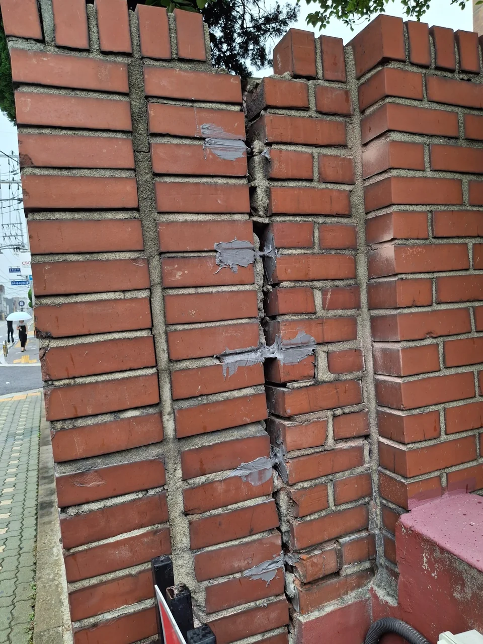 벌어진 벽돌 담장 연결부 여러 높이에 에폭시접착제와 스텐 철근 보강을 진행한 상태