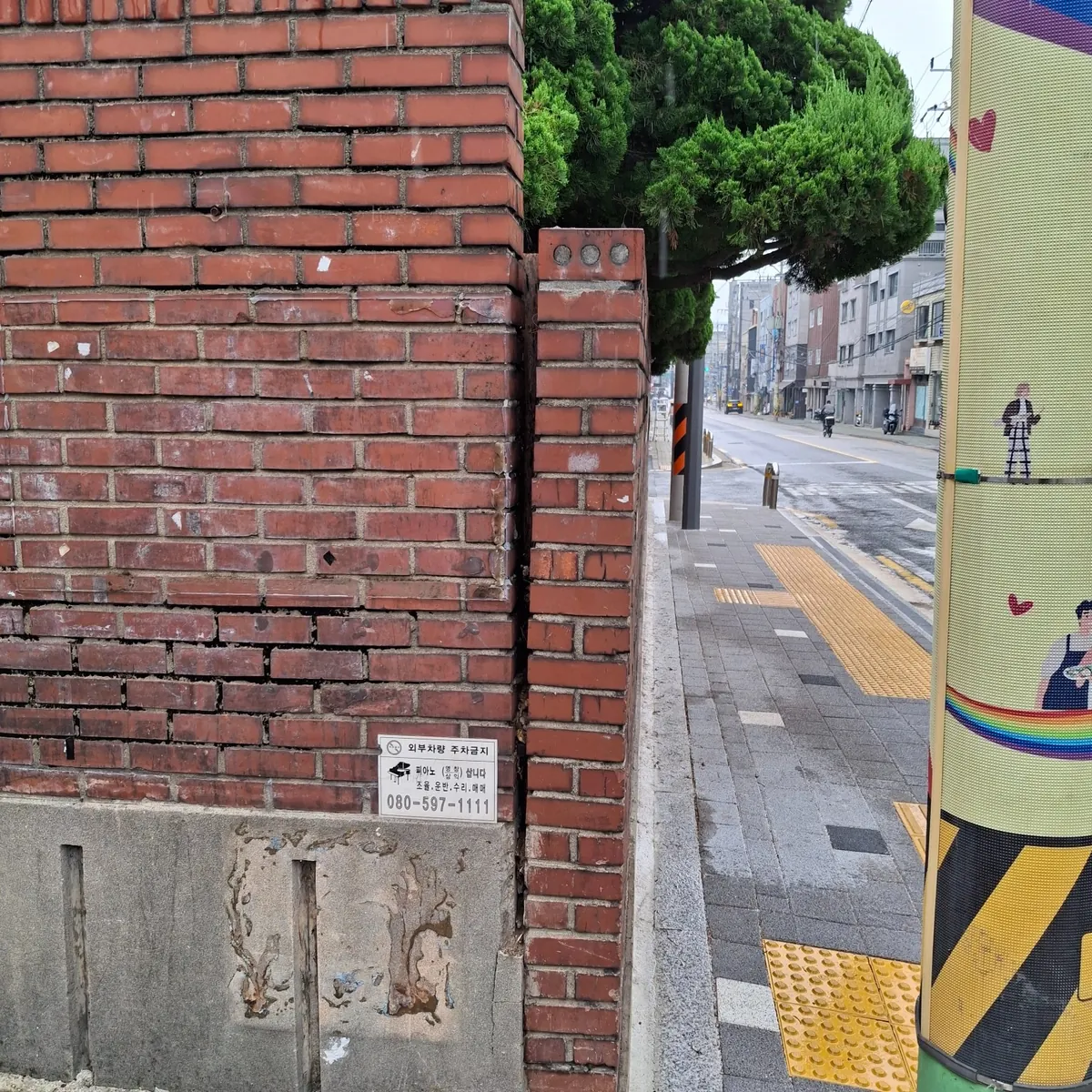 적벽돌 담장 본체와 출입구 옆 벽돌 기둥 사이가 세로로 벌어진 상태