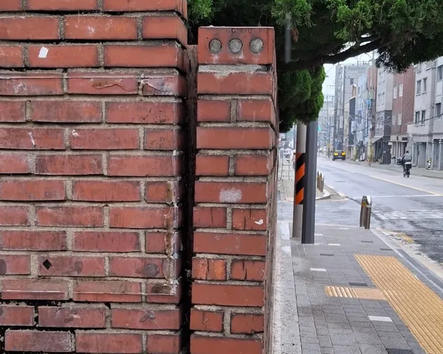 벽돌 담장 본체와 기둥 사이 연결부가 세로로 벌어진 상태