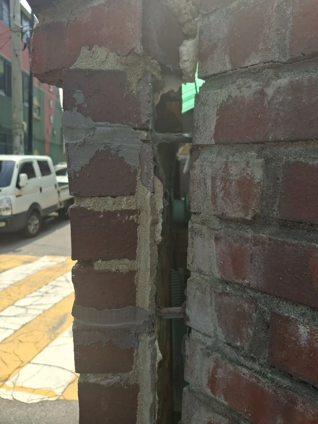 담벼락무너짐보수 중 약 15cm 간격으로 구멍을 뚫고 에폭시를 바른 스텐철근을 넣는 모습